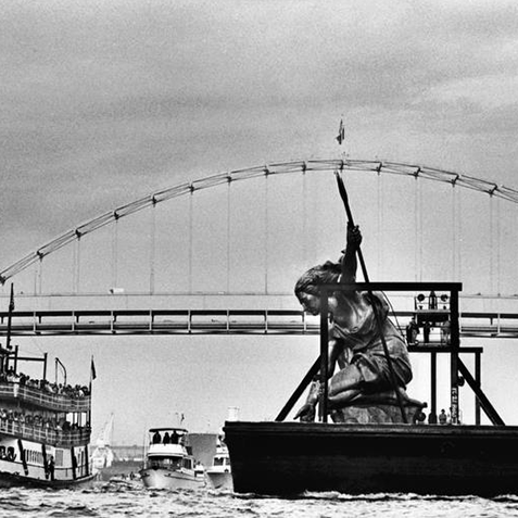 Boats crossing under bridge